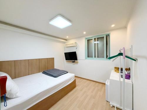 a small bedroom with a bed and a window at Gumi stayraum in Gumi