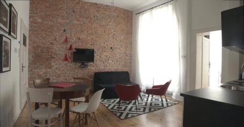 - un salon avec un mur en briques, une table et des chaises dans l'établissement Apartment Rzeznicza, à Wrocław