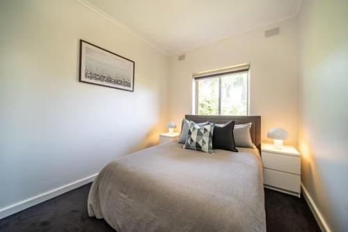 a bedroom with a bed with two lamps and a window at Clouds on Francis - Cosy Comfort off Melbourne St in Bowden