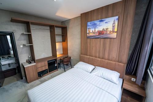 a small bedroom with a bed and a mirror at Trifena Residence in Kalibanteng-lor