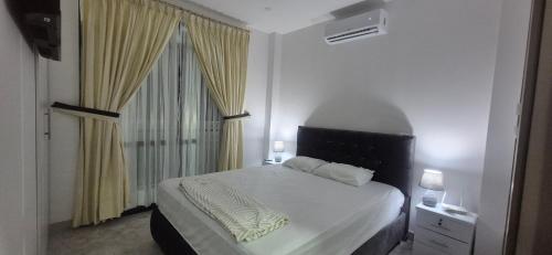 a white bedroom with a bed and a window at Renata's Depar in Punta Blanca