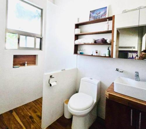 a bathroom with a white toilet and a sink at Casa Mayi Private house with pool in Chablekal in Chablekal