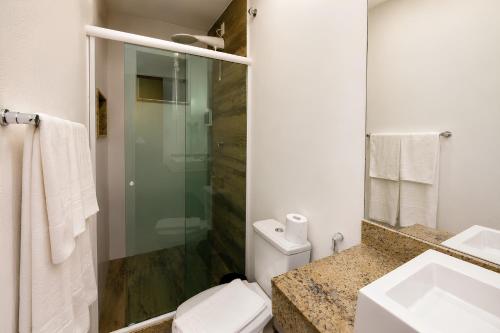 a bathroom with a toilet and a sink and a shower at Hotel Elevare Niteroi in Niterói