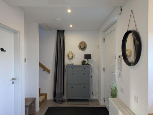 a hallway with a mirror and a dresser at Heilige-Hafen-Lodge in Heiligenhafen