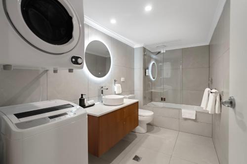 a white bathroom with a sink and a toilet at Quest Mont Albert in Box Hill