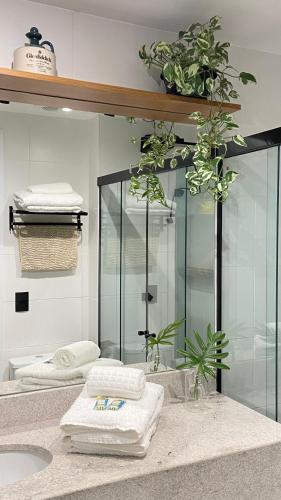 a bathroom with a glass shower and towels on a counter at Apartamento prox a Arena Niteroi, Uff e Barcas in Niterói