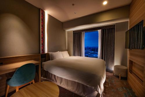 a hotel room with a bed and a window at Hotel Granvia Okayama in Okayama