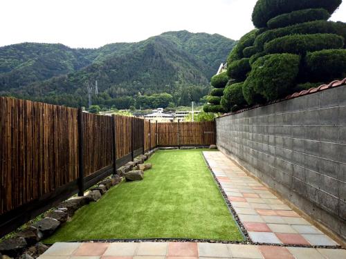 a backyard garden with a fence and grass at MITSU-House in Nishikatsuracho