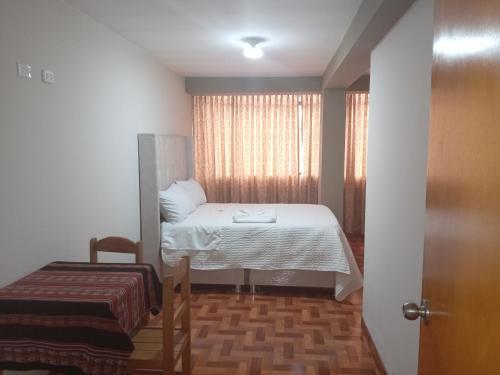 a small room with a bed and a window at Hospedaje San Isidro in Cali