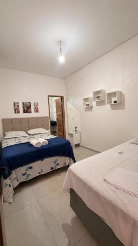 a bedroom with two beds and a wall with pictures at Casa Luxo & Conforto com 4 camas e 2 quartos completa in Juazeiro do Norte