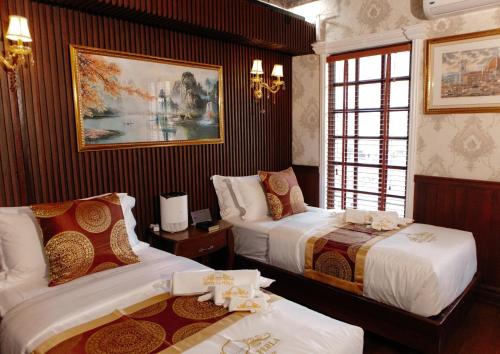 a bedroom with two beds and a painting on the wall at San Franz Hotel La Perla in San Francisco