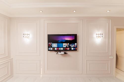 a room with white walls with a flat screen tv on the wall at Miracle Apartment in Samarkand