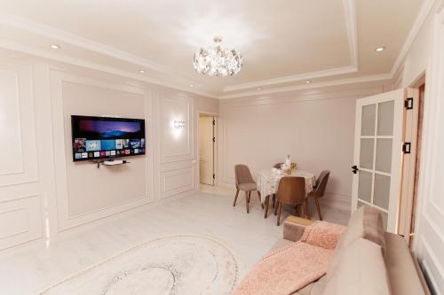 a living room with a table and a tv on the wall at Miracle Apartment in Samarkand