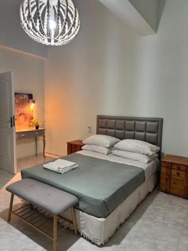 a bedroom with a bed and a table and a chandelier at Villa Costa in Periyiálion