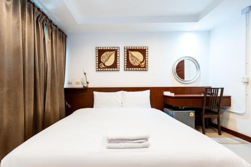 a bedroom with a white bed and a desk at XXYon INN Sukhumvit 4 - ยอน อินน์ 4 in Bang Kapi