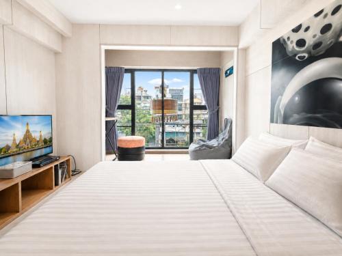 a bedroom with a large bed and a large window at Sleep Walker Poshtel in Chiang Mai