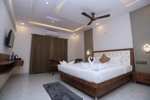 a bedroom with a large bed with a ceiling fan at Shree Durga Paradise in Kalyānpur