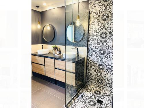 a bathroom with a sink and two mirrors at The Orchard Escape - Cromwell in Cromwell