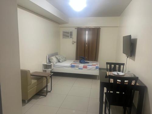 a room with a bed and a chair and a table at Studio 7 in Manila