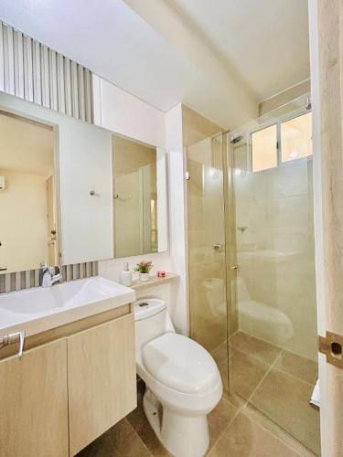 a bathroom with a toilet and a sink and a shower at Capriela Serena del Mar in Cartagena de Indias