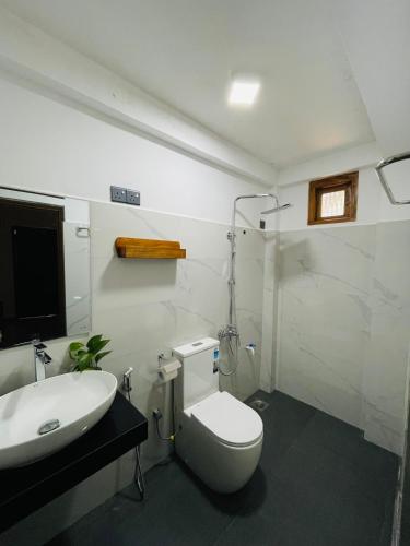 a bathroom with a white toilet and a sink at Ella Solara Heaven in Ella
