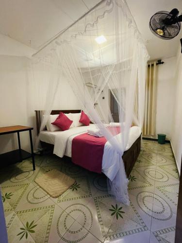 a bedroom with a bed with a mosquito net at Ella Solara Heaven in Ella