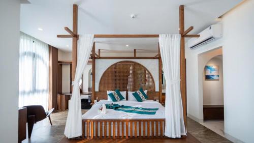 a bedroom with a large bed with a canopy at Cactus Villa in Dong Hoi