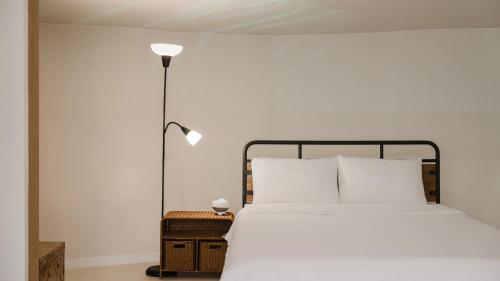 a bedroom with a white bed and a lamp at Gapyeong Pine4rest Glamping in Gapyeong
