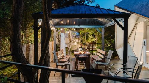 a gazebo with chairs and a table on a deck at Gapyeong Pine4rest Glamping in Gapyeong