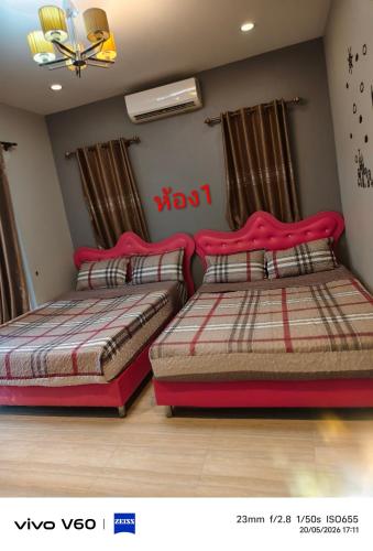 two beds sitting next to each other in a bedroom at Splash Paradise Villa in Cha Am