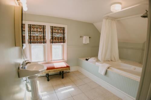 a bathroom with a tub and a sink at The Inn at Ragged Edge in Chambersburg
