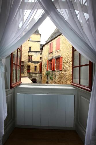 Cette chambre dispose d'une fenêtre offrant une vue sur un bâtiment. dans l'établissement Le Royere, à Sarlat-la-Canéda