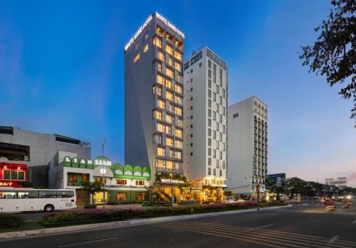 two tall buildings on a city street at night at White Sand Boutique Hotel in Danang