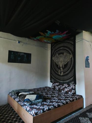 a bed in a room with a painting on the wall at The North Rememberzz in Kalgha