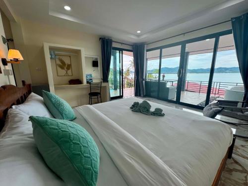 a bedroom with a large bed with a large window at Leam Sai Seaview in Ban Laem Sai