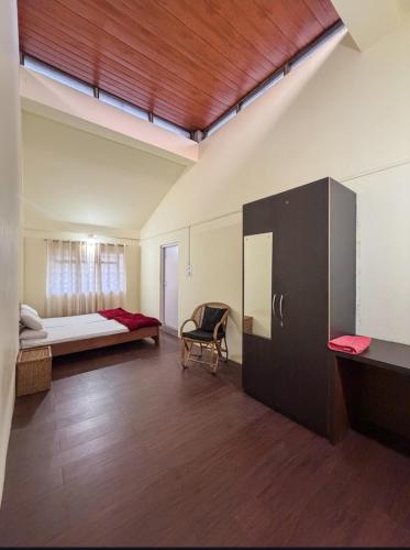 a room with a bedroom with a bed and a chair at Green View Bungalow in Shillong