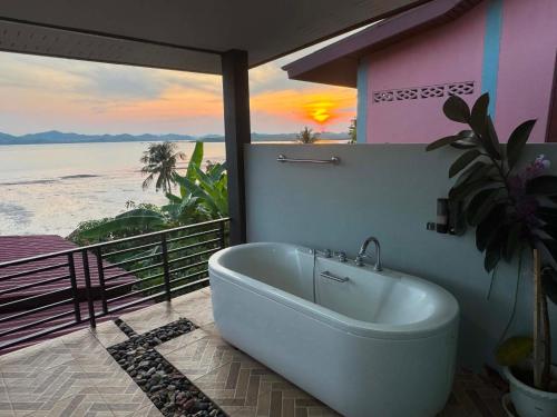 a bath tub in a room with a view of the ocean at Leam Sai Seaview in Ban Laem Sai