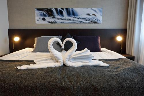dois cisnes feitos de toalhas numa cama em Fosshotel Reykjavík em Reykjavík