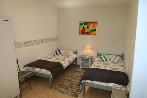 a room with two beds and a table and a lamp at Mas Manyaques in Le Tech