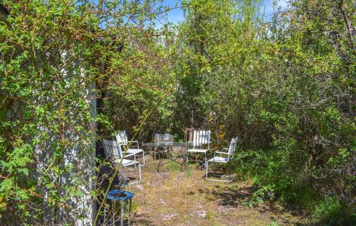 a garden with chairs and a table under trees at Stunning Home In Borrby in Borrby