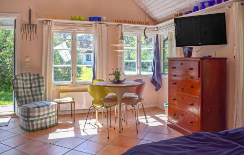 a bedroom with a table and chairs and a tv at Stunning Home In Borrby in Borrby