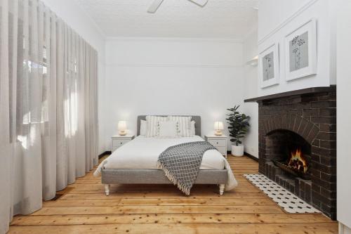 a bedroom with a bed and a fireplace at Barnard Bungalow in Bendigo