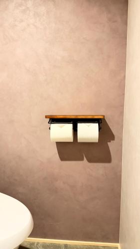 two rolls of toilet paper hanging on a wall at Loving Garden Stayラビングガーデンステイ in Mima