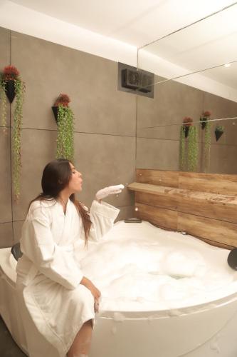a woman sitting on a bed in front of a mirror at Hotel Welcome Palace in Surat
