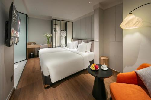 a hotel room with a white bed and a table at Hoan Kiem Legend Ha Noi Hotel in Hanoi