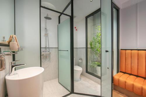 a bathroom with a glass shower with a toilet and a sink at Hoan Kiem Legend Ha Noi Hotel in Hanoi