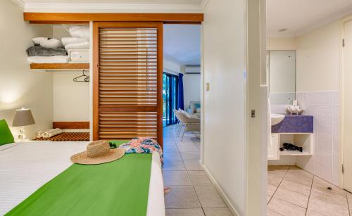 a bedroom with a bed with a hat on it at Freestyle Resort Port Douglas in Port Douglas