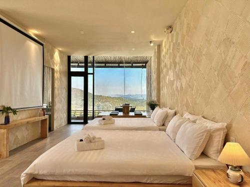 a bedroom with two beds and a large window at Stardome Apartment Dalat in Ấp Ða Lợi
