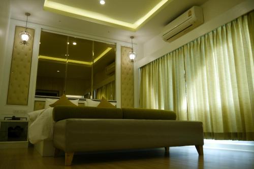 a living room with a couch and a large mirror at Lertnimit Hotel in Chaiyaphum