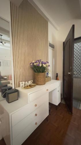 a white counter with a basket of flowers on it at Mellow Place Staycation in Naic